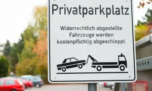 Schild "Privatparkplatz": Widerrechtlich abgestellte Fahrzeuge werden kostenpflichtig abgeschleppt. Wer zahlt den Abschleppdienst? Der Falschparker!