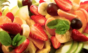 Bunter Obstsalat mit Erdbeeren, Bananen, Mandarinen, Äpfeln und Trauben. Ein erfrischendes, gekochtes Obst-Erlebnis.