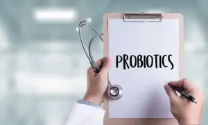 Lekarz trzyma stetoskop i notatnik z napisem "PROBIOTICS". Zastanawia się, do kiedy podawać probiotyk niemowlakowi.