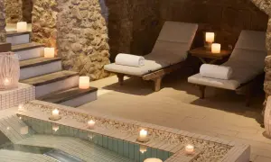 Relájate en este spa urbano con piscina, tumbonas y velas. Un oasis de paz y tranquilidad.
