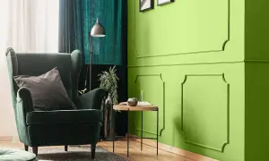 Zielona, aksamitna sofa i zasłony tworzą przytulną atmosferę. Kolor oliwkowy z jakim kolorem pasuje? Zobacz, jak świetnie komponuje się z jaskrawą zielenią ścian.
