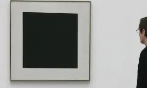 Ein Mann betrachtet ein schwarzes Quadrat auf hellem Grund. Die schlichte Komposition lässt Raum für Interpretationen, die schwarzes Quadrat Bedeutung.