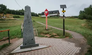 Pomnik na trójstyku Jaworzynka. Znaki graniczne i drogowskazy wskazują trasę.