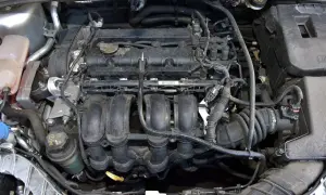 Silnik Ford Focus MK3 1.6 benzyna, widok z góry. Widać kolektor dolotowy, cewki zapłonowe i inne elementy.