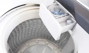 Cassetto aperto della lavatrice, mostra dove mettere detersivo lavatrice. Si vedono i vani per i prodotti e la ventola per la distribuzione.