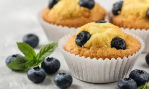 Pyszne muffinki z borówkami, świeże i pachnące, z dodatkiem listków mięty. Idealne na deser.