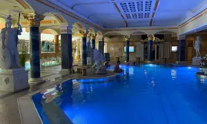 Prunkvoller Innenpool mit blauer Beleuchtung, antiken Statuen und Säulen. Ein Ort der Entspannung in den Teplice Therme.