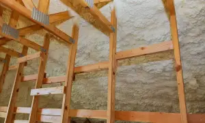 Drewniana konstrukcja strychu pokryta pianką PUR. Zastanawiasz się, ile kosztuje ocieplenie strychu pianką?