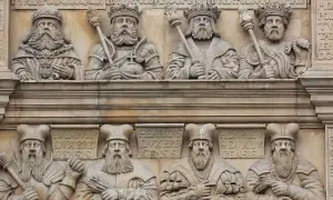 Kamienne płaskorzeźby przedstawiające królów i książąt w koronach i z berłami.