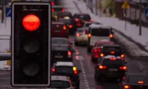 Czerwone światło na sygnalizatorze, za nim sznur samochodów. Zastanawiasz się, po jakim czasie przychodzi mandat za przejazd na czerwonym świetle?