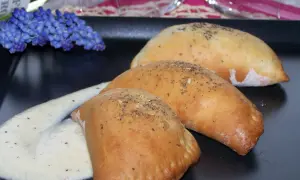 Pyszne pierożki z ciasta drożdżowego, posypane ziołami, podane z kremowym sosem. Idealne, gdy zastanawiasz się, co zrobić z drożdży.