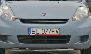 Przód szarego samochodu z widocznym logo Daihatsu i tablicą rejestracyjną EL 077FV.