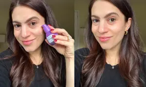 Mujer sonriente aplica sérum con retinol en sus labios para un brillo juvenil.