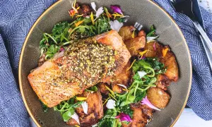 Filet de saumon croustillant, parsemé de graines, servi avec des pommes de terre rôties et une salade verte. Un accompagnement poisson savoureux et coloré.