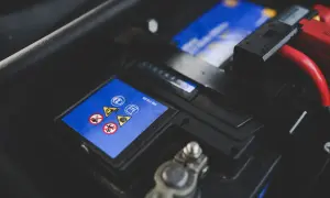 Bilbatteri med varningssymboler. Ett dåligt bilbatteri symptom kan vara att bilen inte startar.