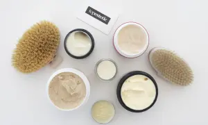Kremy i peelingi do ciała, szczotki do masażu i wizytówka z napisem "topestetic". Wiele z tych produktów zawiera phenoxyethanol w kosmetykach, zapewniając ich trwałość.