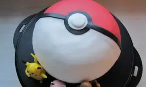 En pokemon tårta formad som en pokéboll med Pikachu, Jigglypuff och Charmander.