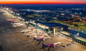 Lotnisko Katowice-Pyrzowice nocą, z samolotami na płycie i oświetlonym terminalem. Rozkład lotów pyrzowice jest dynamiczny.