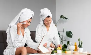 Dos mujeres disfrutan de ideas de spa en casa. Una se aplica maquillaje mientras la otra corta limón para una mascarilla facial.