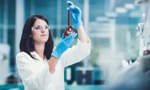 Naukowczyni w laboratorium bada płyn w kolbie. Czy leczenie biologiczne to chemia? Badania naukowe pomagają odpowiedzieć na to pytanie.