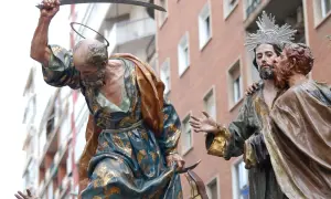 Escena de la **procesión Domingo de Ramos**: un hombre con túnica dorada levanta un sable, mientras otro hombre besa a Jesús.