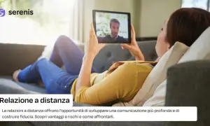 Donna su divano in videochiamata con partner. Psicologia delle relazioni a distanza: comunicazione e fiducia.