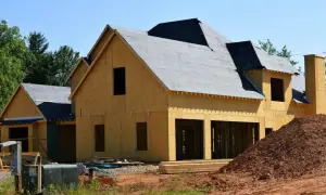 Budowa domu: szkielet z płyt OSB, pokryty papą dach, widoczne otwory okienne i drzwiowe.