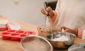 Przygotowania do pieczenia muffinek w silikonowych foremkach. Mieszanie masy w misce trzepaczką.