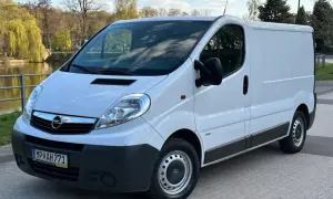 Biały Opel Vivaro 2.0 CDTI zaparkowany przy wodzie, gotowy do podróży.