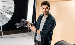 Świetny fotograf z aparatem w studiu. Widać jego pasję i talent.