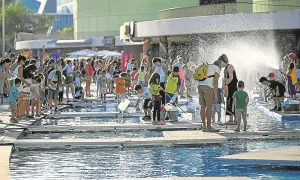Niños y adultos disfrutan de un **espacio río y juego** con actividades acuáticas bajo el sol.