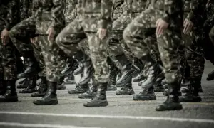 Żołnierze w mundurach maszerują w szyku. To obraz mobilizacji w Polsce, symbol gotowości i siły.