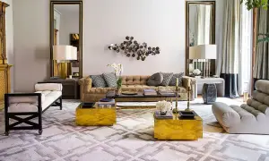 Sofá de terciopelo marrón, mesas doradas y alfombra geométrica crean una acogedora **conversation pit**.