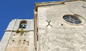 Campanile e rosone di Sant'Elia a Peschici, con il cielo azzurro sullo sfondo.