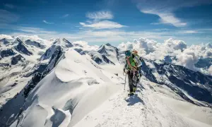 Bergsteiger auf einem schneebedeckten Grat, die Aussicht ist wie eine spaghetti runde.
