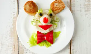 Uśmiechnięta buźka z kotlecików i purée, ozdobiona warzywami. Idealne przekąski dla niemowlaka, które zachęcą do jedzenia.