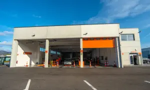 Estación de ITV con coches esperando para pasar la inspección. Un conductor decide pasar la ITV antes de tiempo para evitar multas.
