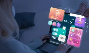 Persona trabajando en el diseño web de una aplicación, con elementos de UI/UX flotando sobre la pantalla.