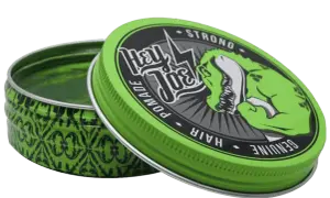 Zielona puszka z pomadą do włosów Hey Joe. T-Rex z napisem "STRONG HAIR" pokazuje bicepsy.