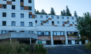 Bâtiment abandonné tagué, vestige d'urbex près du Puy de Dôme. La nature reprend ses droits, fenêtres brisées et végétation envahissante.