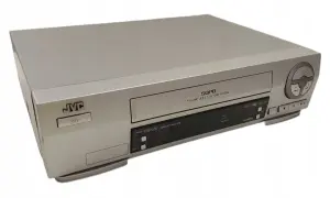 Srebrny vcr JVC z napisem SQPB. Urządzenie posiada przyciski sterujące i slot na kasetę.
