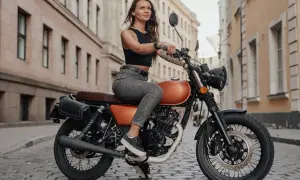 Kobieta na motocyklu w mieście. Chcesz wiedzieć, prawo jazdy a1 od ilu lat? Już od 16 roku życia można je zdobyć!