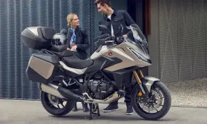 Para zwiedzająca motocykle z automatyczną skrzynią biegów. Nowoczesny turystyczny motocykl Honda z kuframi.