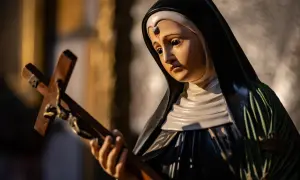Figurka świętej Rity od spraw beznadziejnych trzyma krzyż.