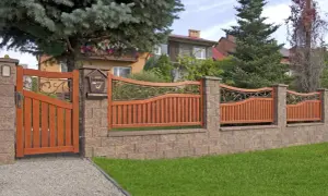 Eleganckie, drewniane ogrodzenie przed domem z ozdobnymi elementami metalowymi i skrzynką na listy.