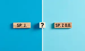 Drewniane klocki z napisami "SP. J." i "SP. Z O.O." oraz znak zapytania na niebieskim tle.