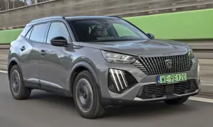 Szary Peugeot 2008 na drodze, kierowca w okularach. Sprawdź aktualną peugeot 2008 cena.