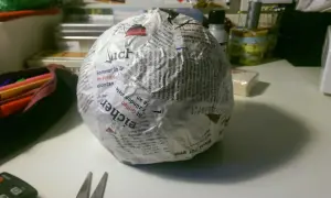 Papierkugel mit Zeitungspapier und Kleister. Die Frage, wie lange braucht Mehlkleister zum trocknen, beschäftigt den Bastler.