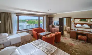 Pokój hotelowy z dwoma łóżkami, widokiem na jezioro i meblami wypoczynkowymi.