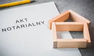 Akt notarialny z symbolem domu z klocków i długopisem.